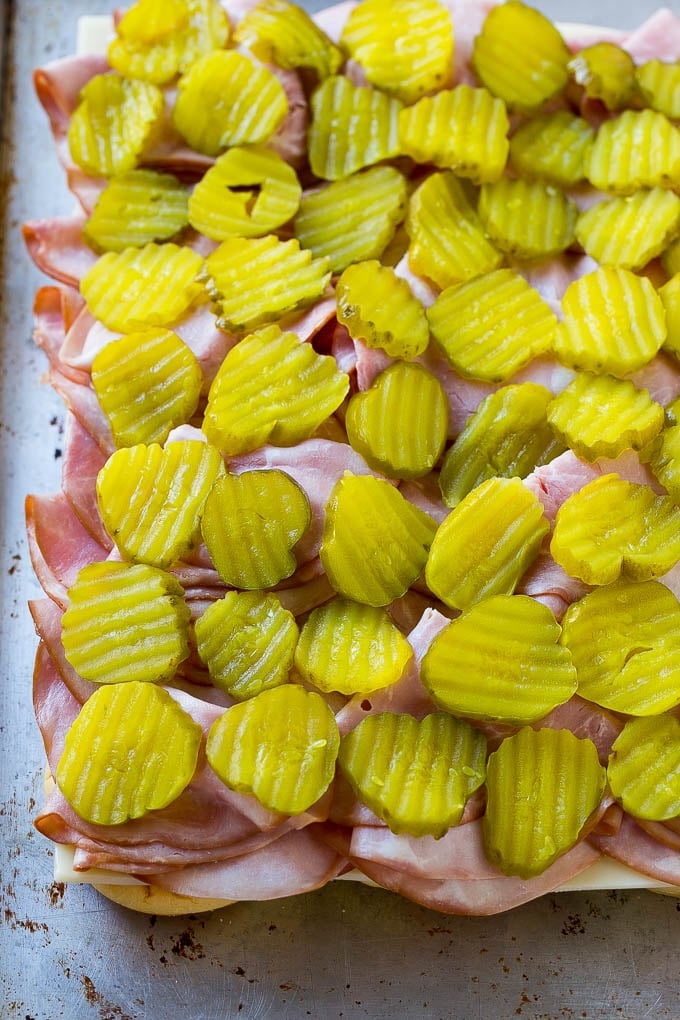 Cuban Sliders Recipe | Cuban Sandwich Recipe | Slider Sandwiches | Ham and Cheese Sliders #sliders #sandwiches #ham #cheese #appetizer #bajap Bread layered with cheese, ham and pickles.