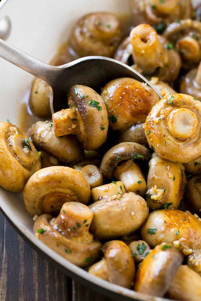 Garlic Mushrooms Recipe | Steakhouse Mushrooms | Sauteed Mushrooms | Garlic Butter Mushrooms | Mushroom Side Dish #mushrooms #butter #keto #lowcarb #dinner #sidedish #bajap A pan of sauteed garlic mushrooms with a serving spoon.