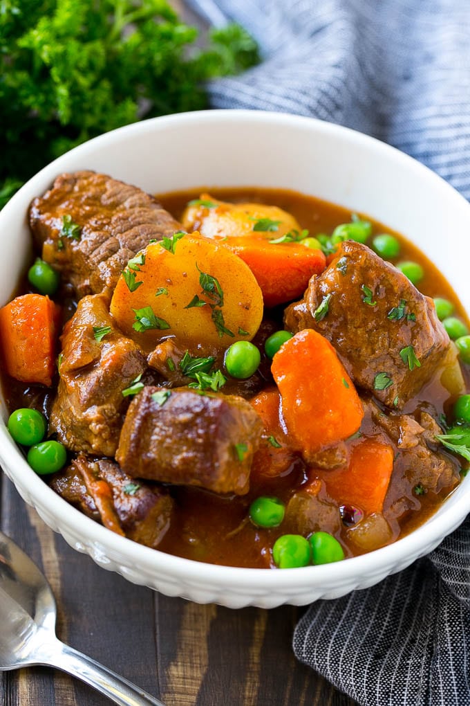 Slow Cooker Beef Stew Recipe | Beef and Potato Stew | Crock Pot Beef Stew | Easy Beef Stew #beef #beefstew #soup #slowcooker #crockpot #dinner #bajap A bowl of slow cooker beef stew with meat, carrots, potatoes and peas.