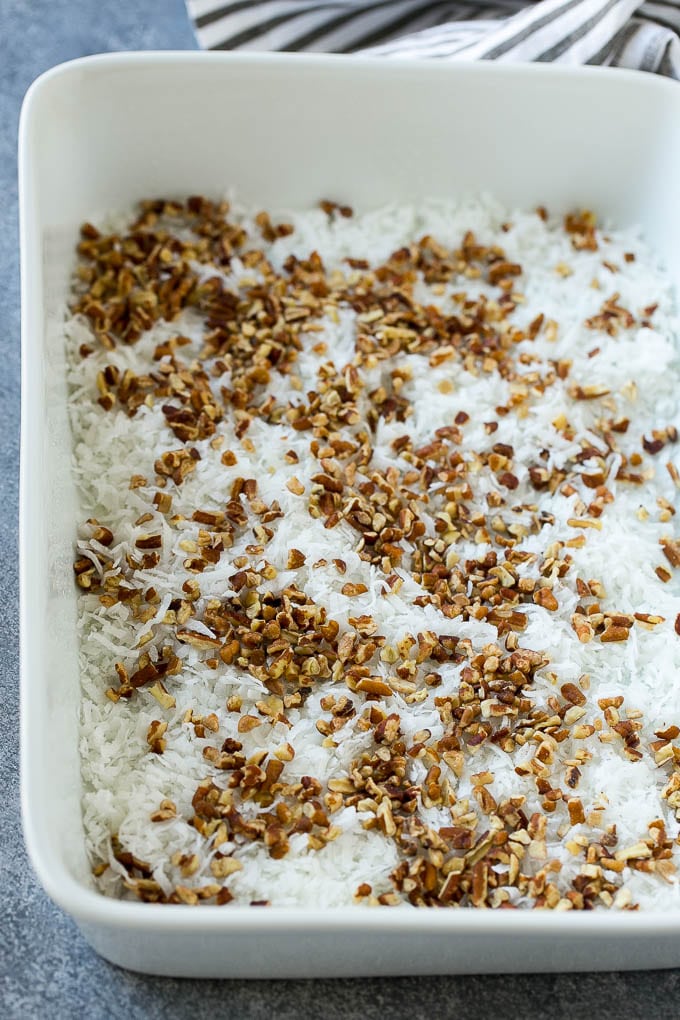 Earthquake Cake Recipe | Chocolate Cake Recipe | Chocolate Coconut Cake | Coconut Pecan Cake #cake #chocolate #coconut #pecans #dessert #chocolatecake #bajap Coconut and pecans layered into a cake pan.
