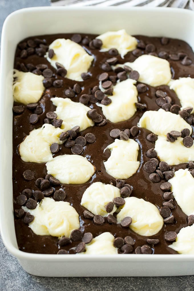 Earthquake Cake Recipe | Chocolate Cake Recipe | Chocolate Coconut Cake | Coconut Pecan Cake #cake #chocolate #coconut #pecans #dessert #chocolatecake #bajap Chocolate cake batter topped with dollops of sweetened cream cheese and chocolate chips.