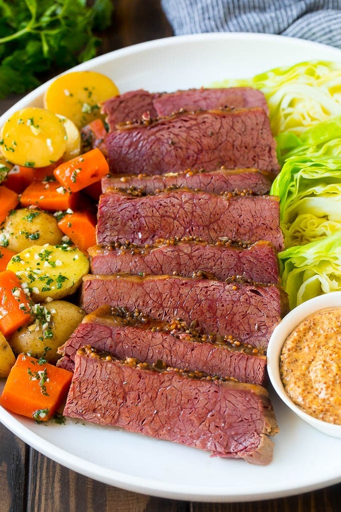 Slow Cooker Corned Beef Recipe | Crock Pot Corned Beef | Corned Beef and Cabbage #beef #cornedbeef #cabbage #potatoes #carrots #stpatricksday #irish #bajap A platter of slow cooker corned beef, cabbage wedges, potatoes and carrots.