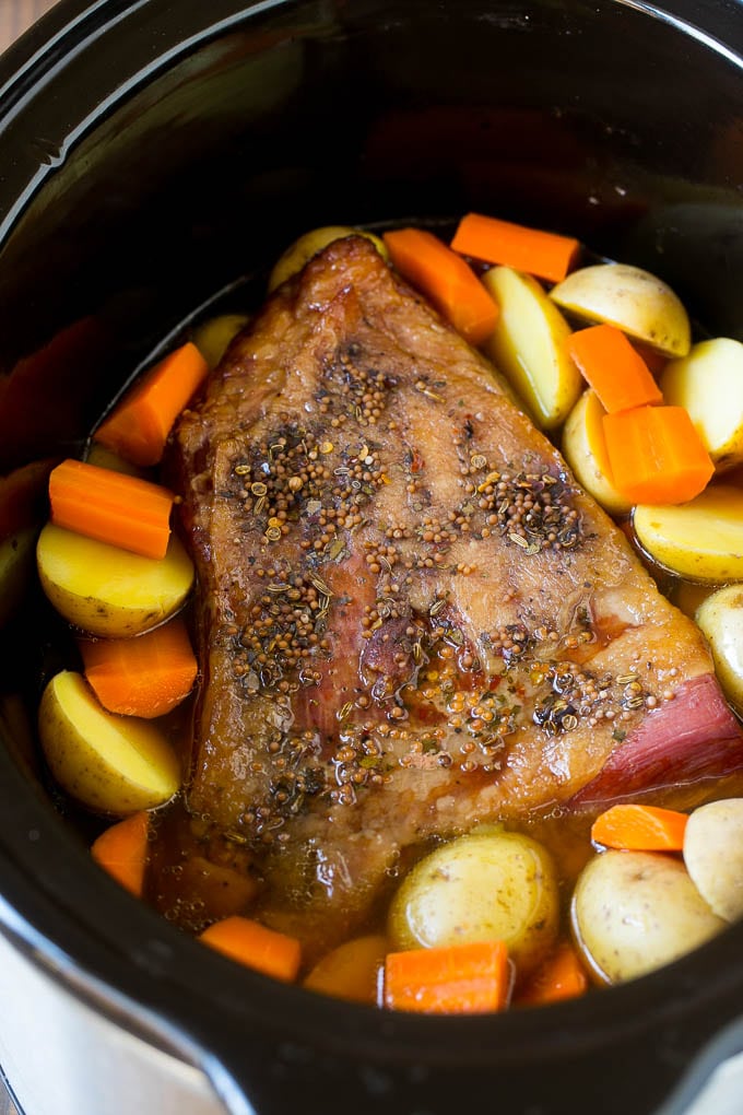 Slow Cooker Corned Beef Recipe | Crock Pot Corned Beef | Corned Beef and Cabbage #beef #cornedbeef #cabbage #potatoes #carrots #stpatricksday #irish #bajap A seasoned brisket with potatoes and carrots in a slow cooker.