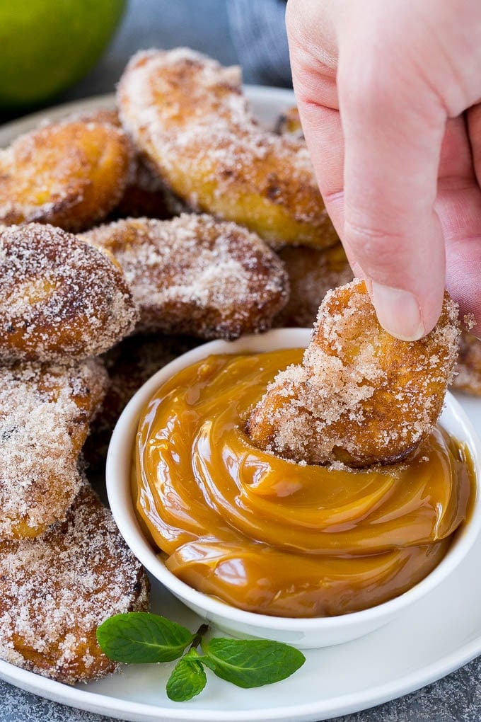 Apple Fries Recipe | Fried Apples Recipe | Cinnamon Sugar Apples | Apple Dessert Recipe #apples #dessert #bajap #fall An apple fry being dipped into caramel sauce.