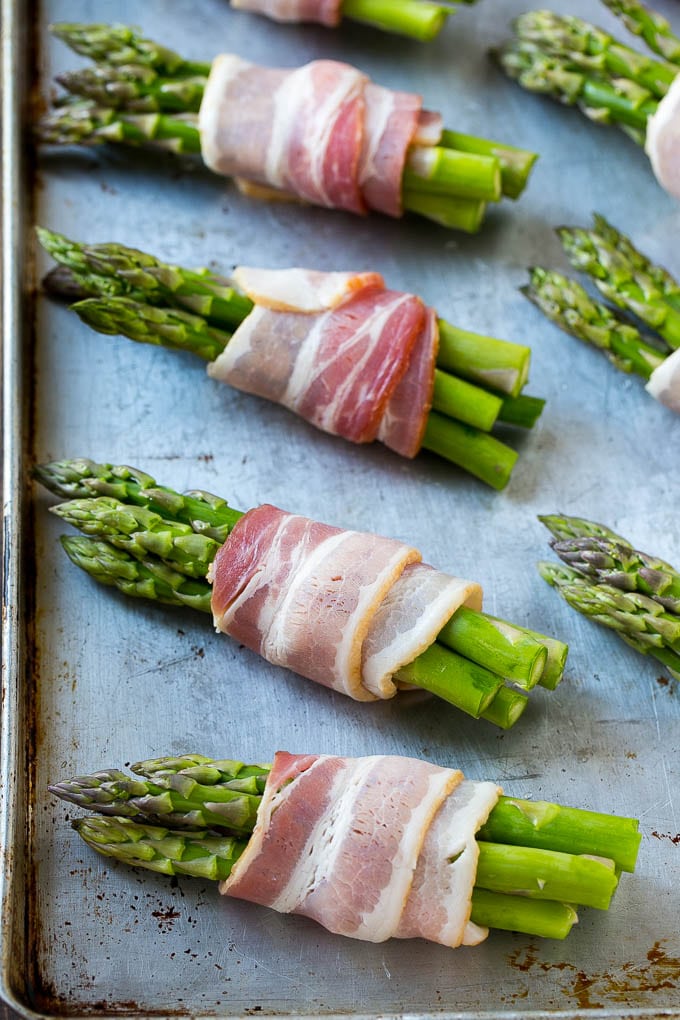 Bacon Wrapped Asparagus Recipe | Roasted Asparagus | Asparagus Side Dish #asparagus #bacon #sidedish #dinner #bajap Raw asparagus bundles on a sheet pan.