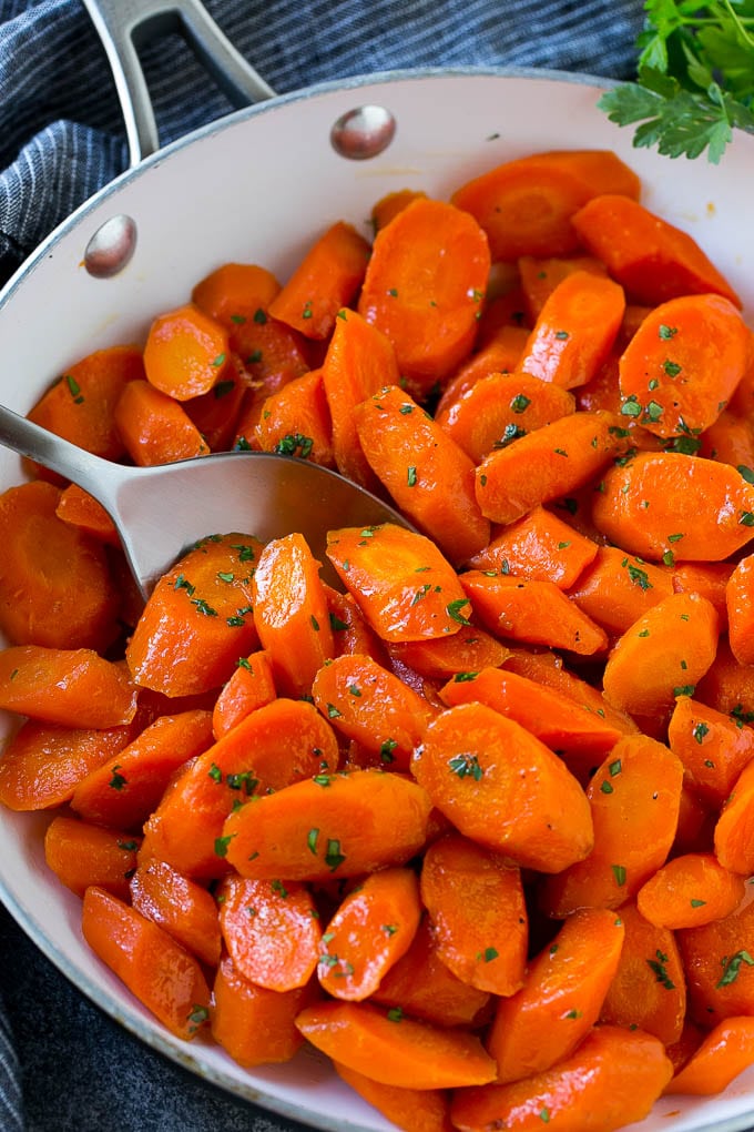 Candied Carrots Recipe | Carrot Side Dish | Brown Sugar Carrots | Glazed Carrots #carrots #brownsugar #sidedish #dinner #bajap Candied carrots in a pan with a serving spoon.