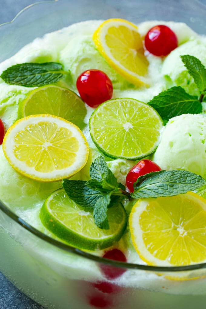 Lime Sherbet Punch | Party Punch Recipe | Sherbet Punch Recipe | Limeade Recipe #sherbet #punch #lime #drink #bajap A close up of a bowl of sherbet punch garnished with citrus and mint.