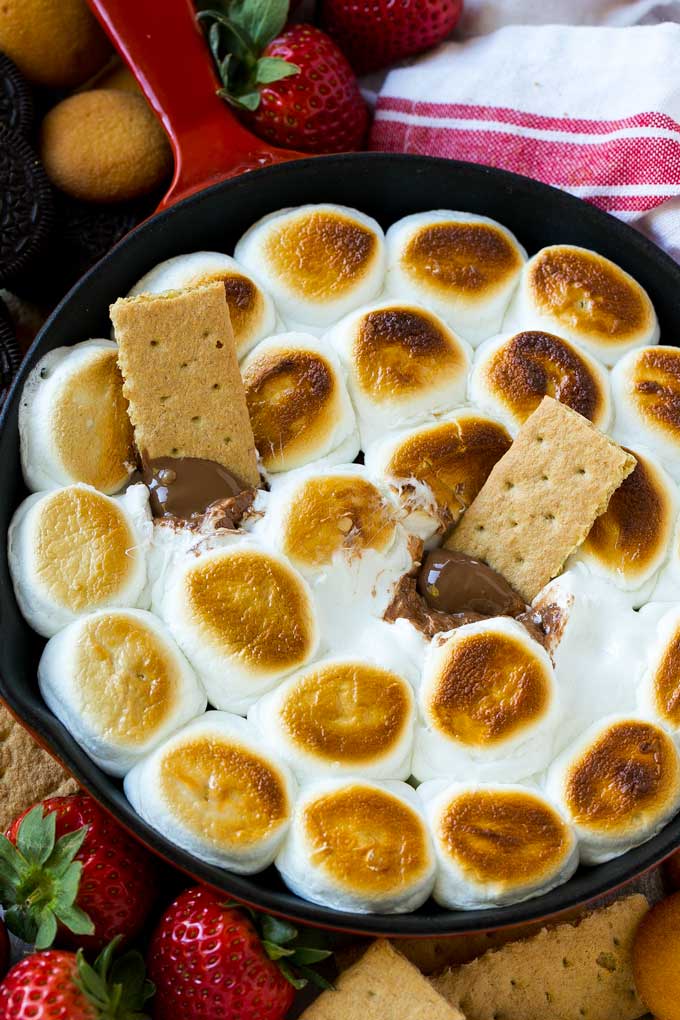 S'mores Dip Recipe | S'mores Skillet | Baked S'mores #smores #dip #chocolate #marshmallow #dessert #bajap A skillet of s'mores dip with melted milk chocolate topped with toasted marshmallows.