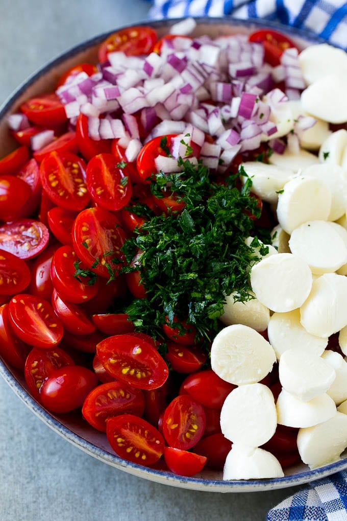 Cherry Tomato Salad Recipe | Tomato Mozzarella Salad | Caprese Salad | Tomato Salad #tomatoes #salad #tomatosalad #caprese #bajap A bowl of halved cherry tomatoes, mozzarella balls, herbs and minced red onion.
