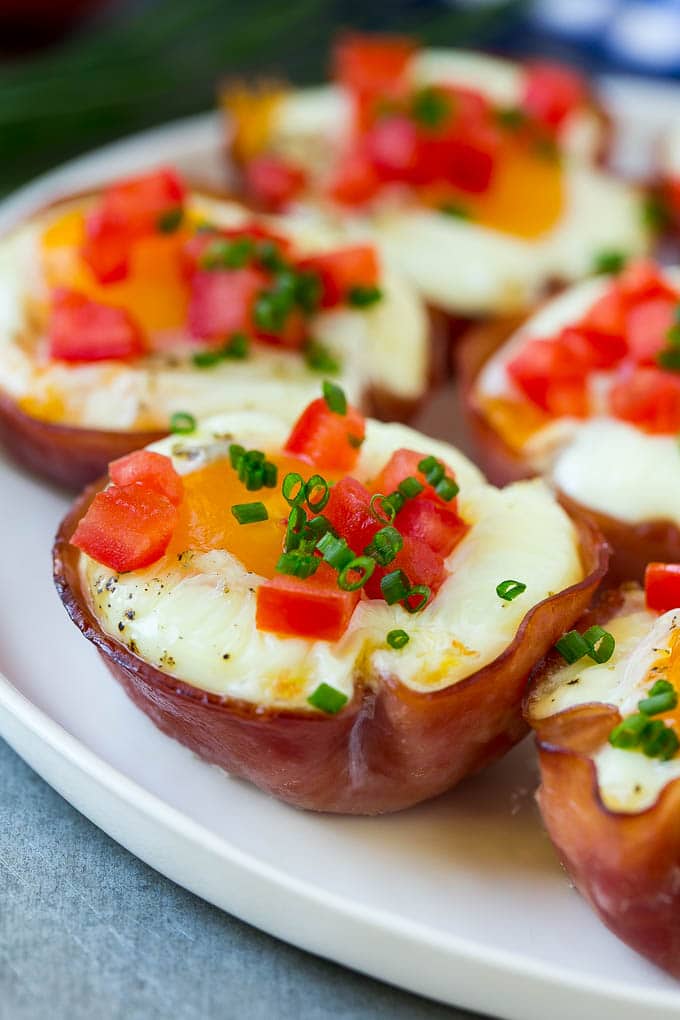 Ham and Egg Cups Recipe | Low Carb Breakfast | Ham and Eggs #ham #eggs #lowcarb #breakfast #bajap A plate of ham and egg cups topped with diced tomatoes and chives.
