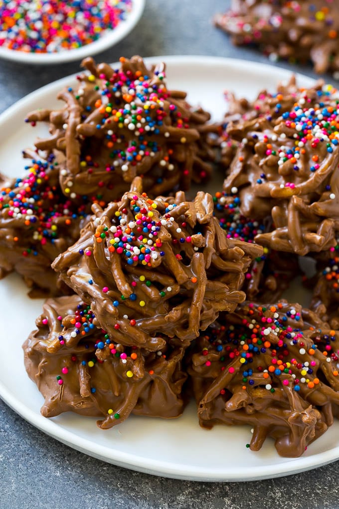 Haystack Cookies Recipe | No Bake Cookies | Chow Mein Noodle Cookies #nobakecookies #cookies #recipe #chocolate #bajap A plate of haystack cookies topped with rainbow sprinkles.