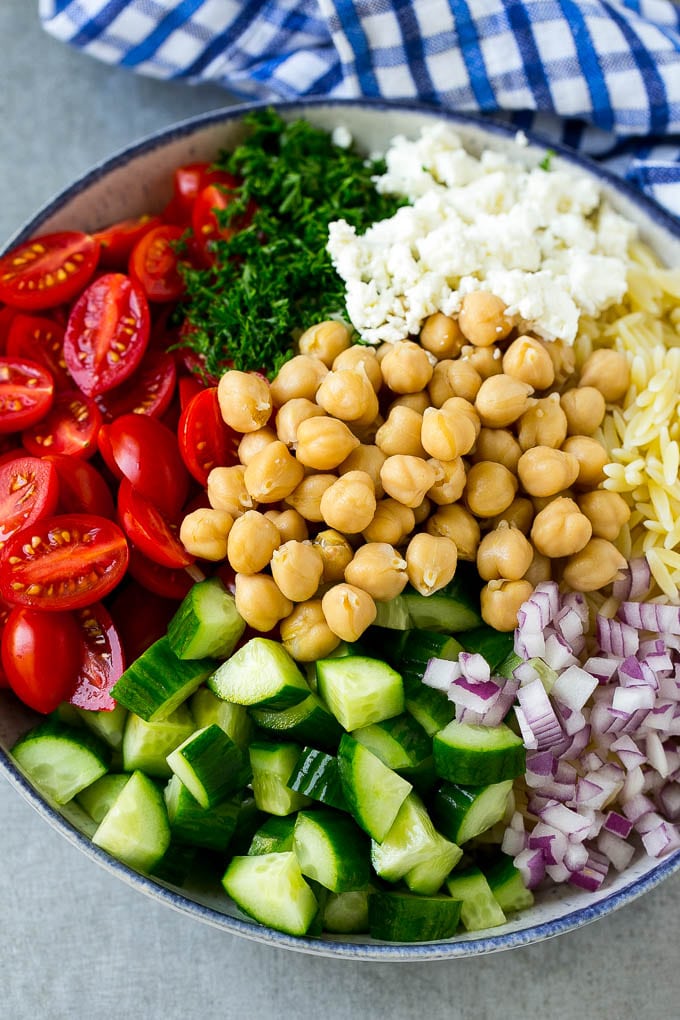 Orzo Salad Recipe | Orzo Pasta Salad | Greek Orzo Salad | Mediterranean Orzo Salad #pastasalad #orzo #greekfood #salad #bajap A bowl of orzo pasta, cucumbers, cherry tomatoes, feta cheese, red onions, herbs and chickpeas.
