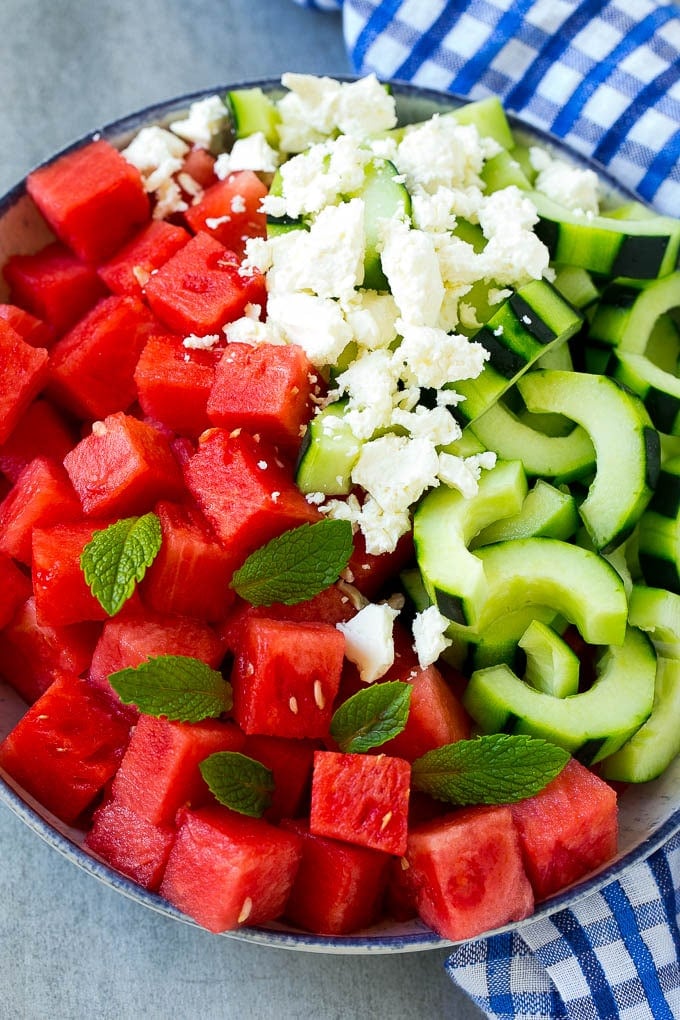 Watermelon Salad Recipe | Watermelon Feta Salad | Watermelon Cucumber Salad #watermelon #cucumber #salad #bajap A bowl of cubed watermelon, sliced cucumbers, feta cheese and mint leaves.