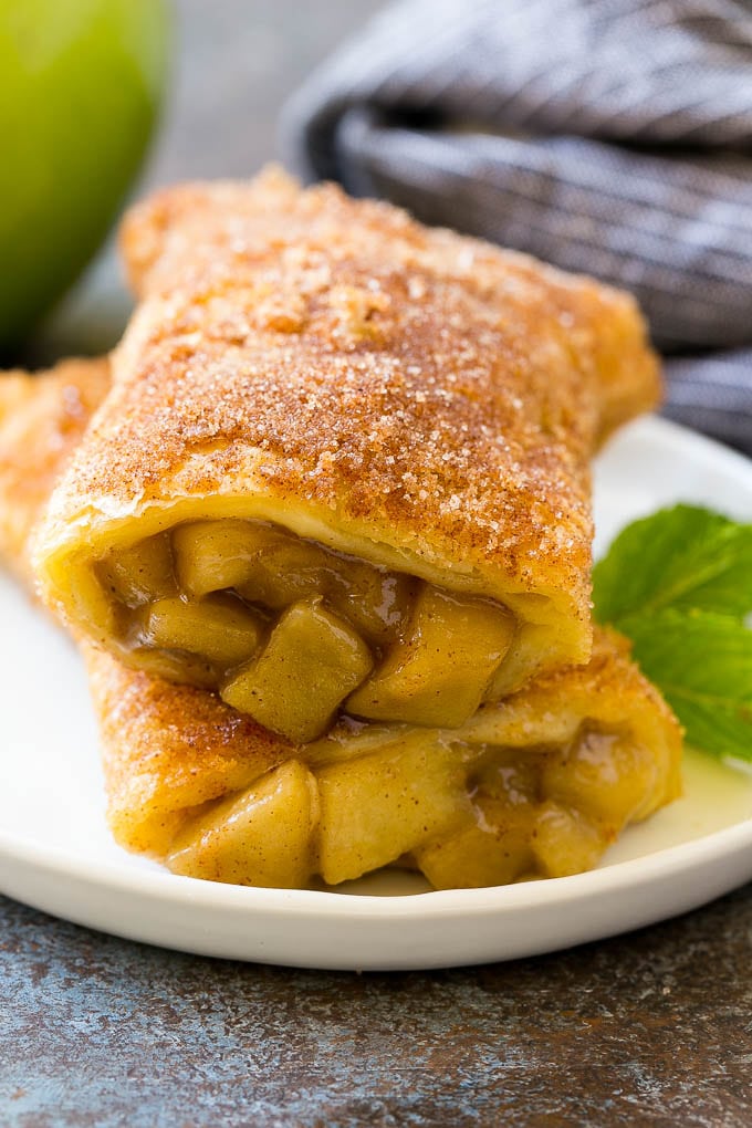Fried Apple Pies Recipe | McDonald's Copycat Recipe | Apple Pie | Apple Hand Pies #pie #apples #applepie #dessert #snack #bajap A cross section of a fried apple pie on a plate.