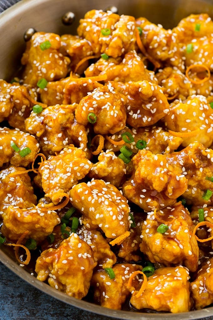 Orange Chicken Recipe | Chinese Orange Chicken | Panda Express Orange Chicken #orange #chicken #takeout #chinesefood #dinner #bajap Orange chicken in a skillet with crispy chicken, sesame seeds, orange zest and green onions.