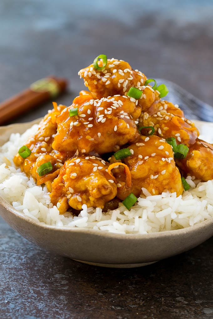 Orange Chicken Recipe | Chinese Orange Chicken | Panda Express Orange Chicken #orange #chicken #takeout #chinesefood #dinner #bajap A bowl of orange chicken served over steamed rice and topped with sesame seeds.