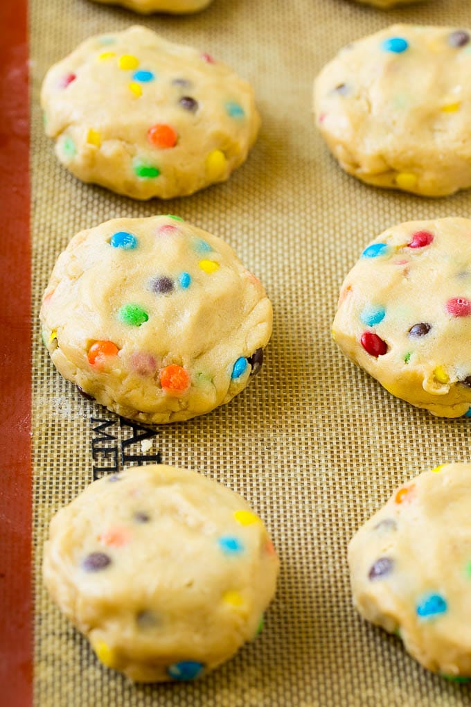 Oreo Stuffed Cookies Recipe | M&M's cookies | Stuffed Cookies #cookies #chocolate #oreos #dessert #baking #bajap Cookie dough balls stuffed with Oreo cookies on a sheet pan.