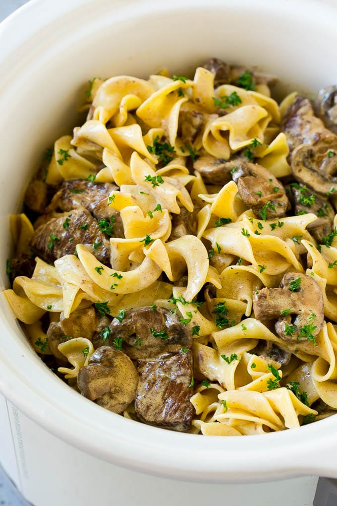 Slow Cooker Beef Stroganoff Recipe | Crock Pot Beef Stroganoff | Beef Recipe #slowcooker #crockpot #beef #mushrooms #pasta #dinner #bajap Slow cooker beef stroganoff with chunks of beef, mushrooms and egg noodles topped with parsley.