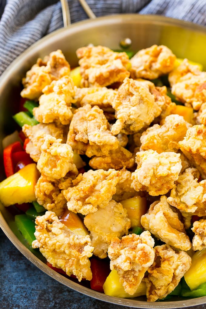 Sweet and Sour Chicken Recipe | Chinese Food Copycat Recipe | Chicken with Pineapple #chicken #chinesefood #pineapple #stirfry #takeout #dinner #bajap Fried chicken pieces in a pan with pineapple, peppers and onions.
