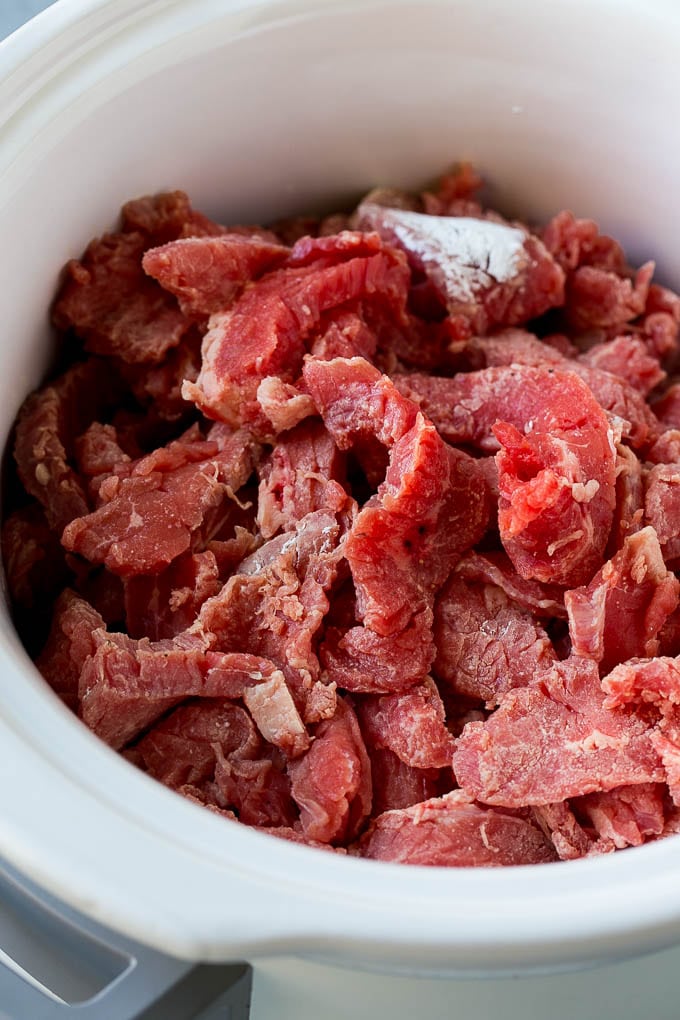 Slow Cooker Korean Beef Recipe | Korean Beef | Flank Steak Recipe #dinner #beef #slowcooker #crockpot #asian #bajap Flank steak strips tossed in cornstarch inside a slow cooker.