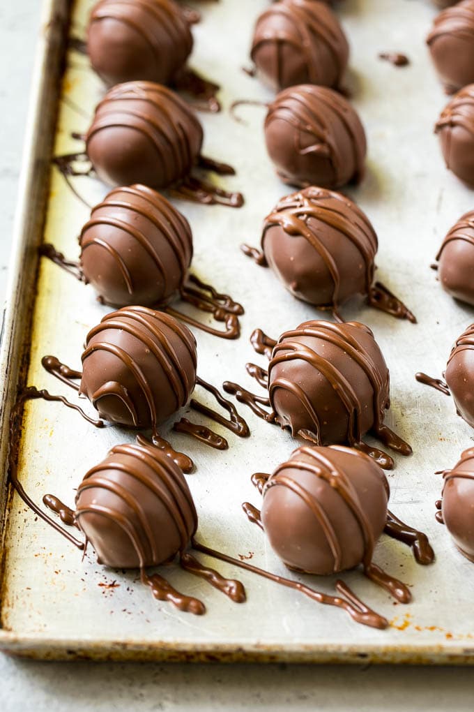 Chocolate Covered Cherries Recipe | Cherry Cordials | Cherry Candy #chocolate #candy #dessert #cherry #sweets #bajap Chocolate covered cherries on a sheet pan with a chocolate drizzle on top.