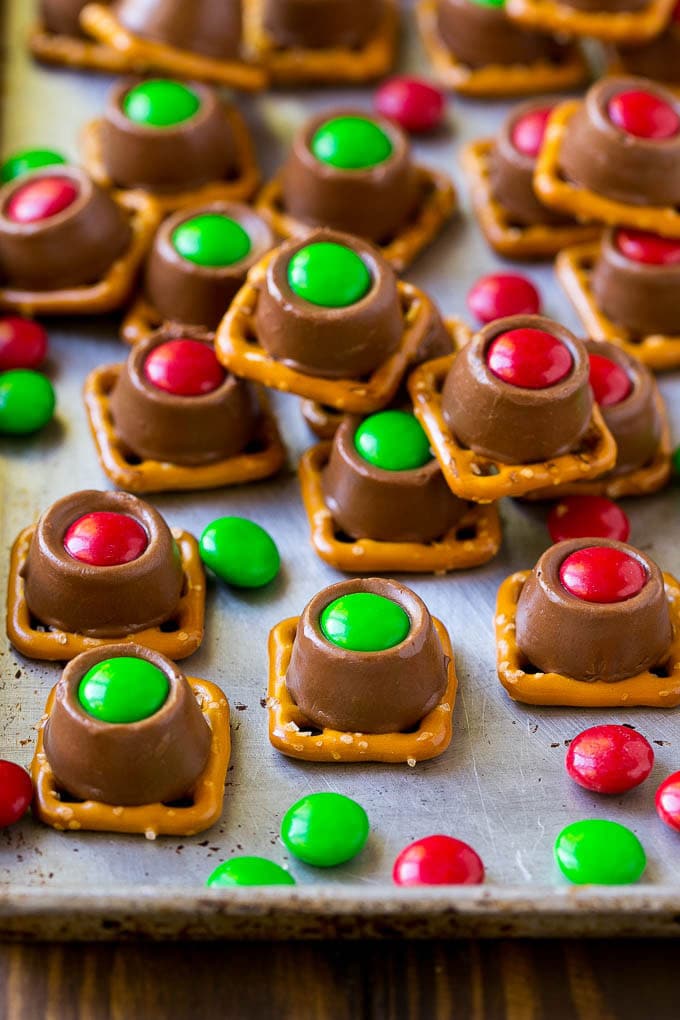 Rolo Pretzels Recipe | Chocolate Pretzels | Caramel Pretzels | Holiday Candy #christmas #baking #dessert #candy #chocolate #caramel #pretzels #bajap Rolo pretzels on a baking sheet topped with red and green M&M's.