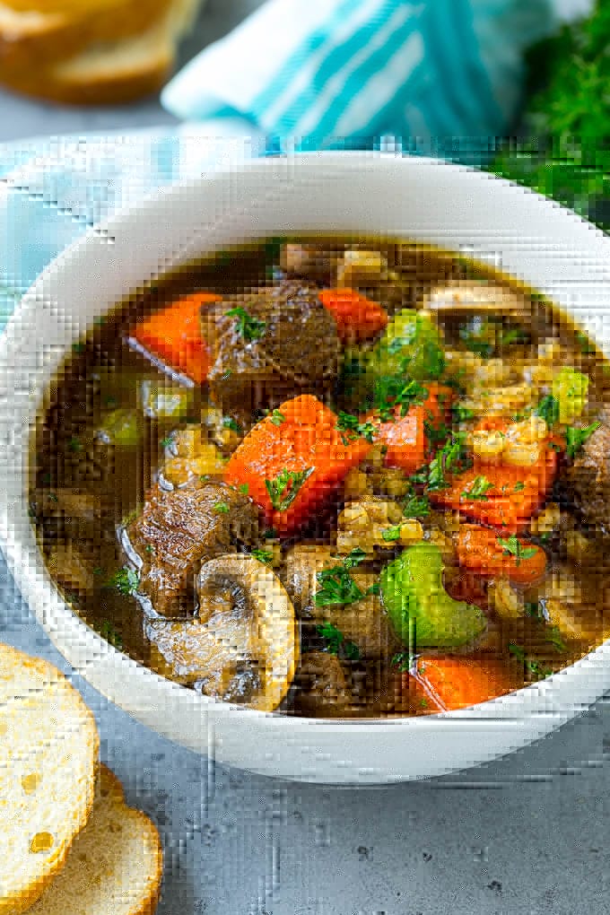 Beef Barley Soup Recipe | Beef Soup | Barley Soup #soup #beef #dinner #vegetables #bajap #comfortfood A bowl of beef barley soup topped with chopped parsley.