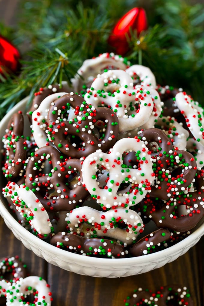 Chocolate Covered Pretzels Recipe | Sprinkle Pretzels | No Bake Dessert #pretzels #chocolate #christmas #sprinkles #candy #bajap Chocolate covered pretzels in a bowl with Christmas sprinkles.