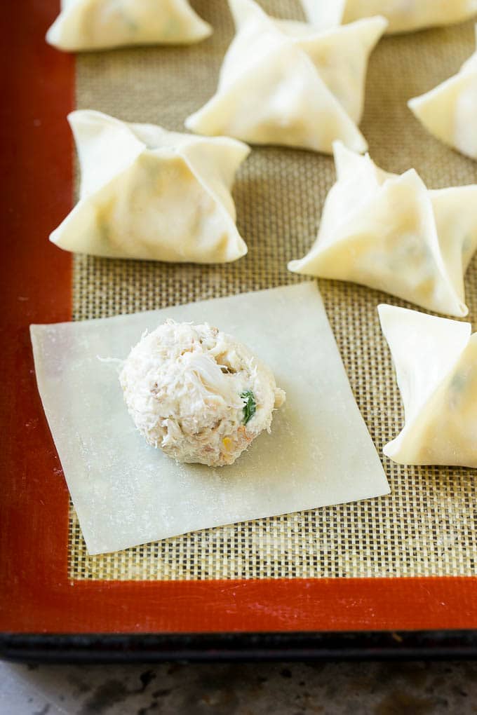 Crab Rangoon Recipe | Crab Wontons | Cream Cheese Wontons #crab #cheese #appetizer #snack #chinesefood #dinner #bajap A wonton wrapper with a dollop of filling on it.