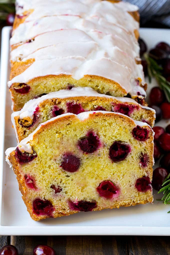Cranberry Bread Recipe | Cranberry Loaf | Cranberry Orange Bread #cranberry #bread #baking #dessert #fall #bajap Slices of cranberry bread topped with orange glaze.