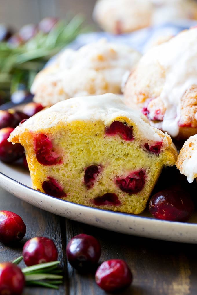 Cranberry Muffins Recipe | Cranberry Orange Muffins #cranberry #muffins #orange #fall #dessert #bajap A plate of muffins with one cut in half.