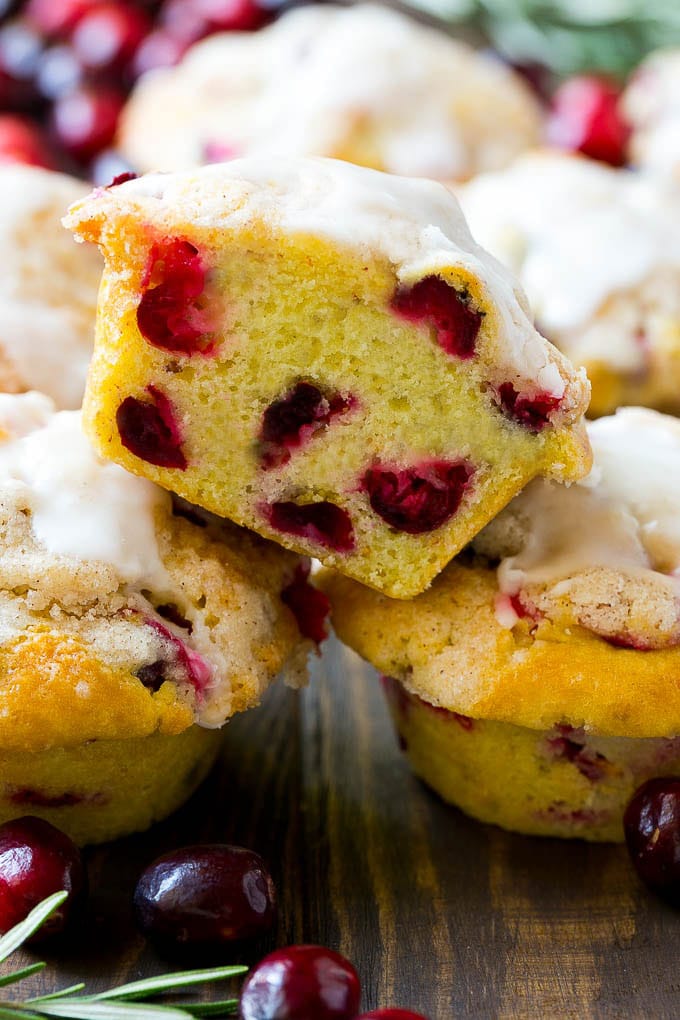 Cranberry Muffins Recipe | Cranberry Orange Muffins #cranberry #muffins #orange #fall #dessert #bajap A stack of cranberry muffins with one muffin cut in half.
