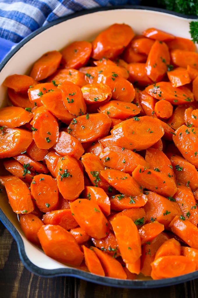 Glazed Carrots Recipe | Brown Sugar Carrots | Carrot Side Dish #carrots #brownsugar #sidedish #glutenfree #thanksgiving #fall #dinner #bajap A skillet of glazed carrots with brown sugar and butter sauce.