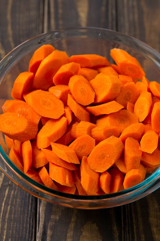 Glazed Carrots Recipe | Brown Sugar Carrots | Carrot Side Dish #carrots #brownsugar #sidedish #glutenfree #thanksgiving #fall #dinner #bajap A bowl of peeled and sliced carrots.