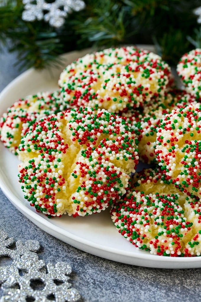 Gooey Butter Cookies Recipe | Cake Mix Cookies | Sprinkle Cookies | Christmas Cookies #cookies #butter #sprinkles #christmas #dessert #baking #bajap A plate of gooey butter cookies covered in holiday sprinkles.