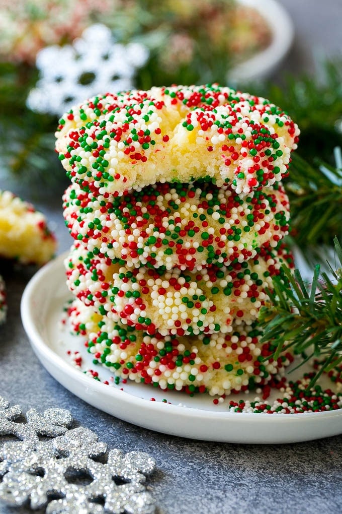 Gooey Butter Cookies Recipe | Cake Mix Cookies | Sprinkle Cookies | Christmas Cookies #cookies #butter #sprinkles #christmas #dessert #baking #bajap A stack of gooey butter cookies with a bite taken out of one.