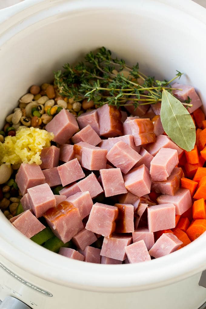 Ham and Bean Soup Recipe | Slow Cooker Ham and Bean Soup | Crockpot Ham and Bean Soup | Leftover Ham Recipe #ham #beans #soup #slowcooker #crockpot #dinner #bajap Vegetables, pork, herbs and garlic in the slow cooker.