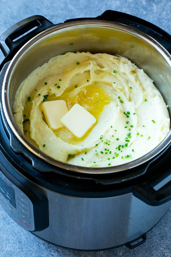 Instant Pot Mashed Potatoes Recipe | Pressure Cooker Mashed Potatoes | Easy Mashed Potatoes #potatoes #sidedish #instantpot #thanksgiving #dinner #bajap Instant Pot mashed potatoes with butter and chives inside a pressure cooker.