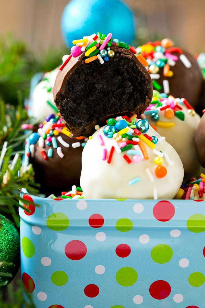 Oreo Balls Recipe | Oreo Truffles | Homemade Candy #truffles #candy #oreos #chocolate #sprinkles #dessert #christmas #bajap A cross section of an Oreo ball inside a holiday gift tin.