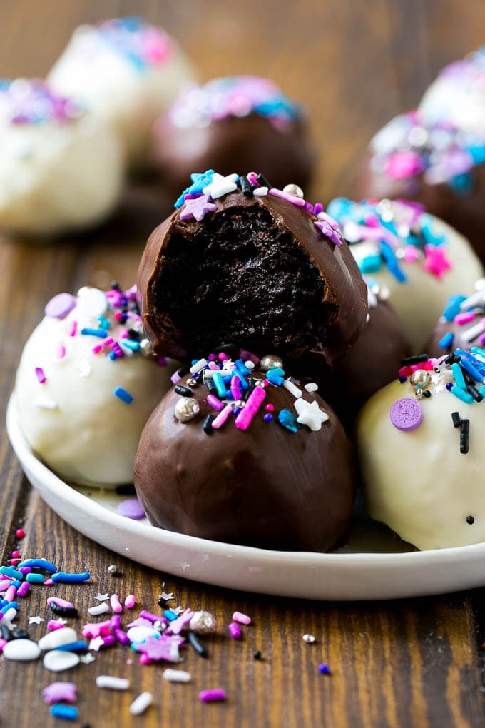 Oreo Balls Recipe | Oreo Truffles | Homemade Candy #truffles #candy #oreos #chocolate #sprinkles #dessert #christmas #bajap A plate of dark and white chocolate Oreo balls topped with colorful sprinkles.