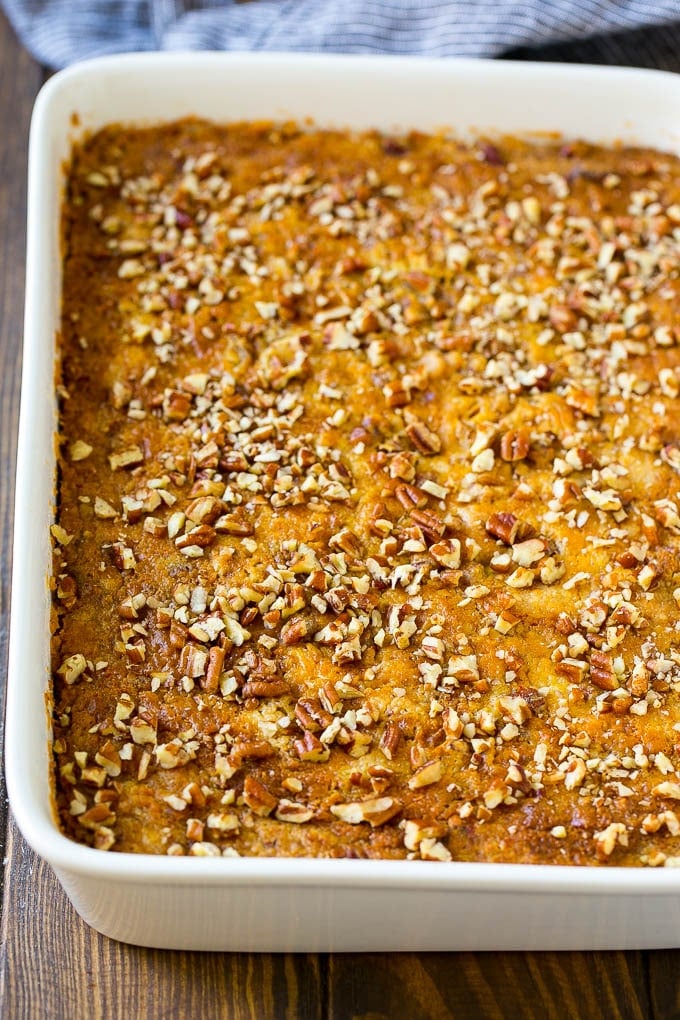 Pumpkin Dump Cake Recipe | Pumpkin Cake | Pumpkin Pie Cake #pumpkin #cake #pecans #fall #thanksgiving #dessert #bajap A pan of pumpkin dump cake topped with chopped pecans.