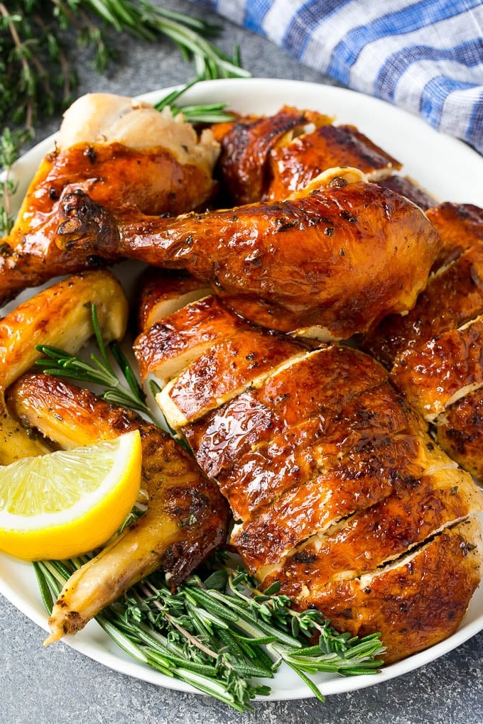 Roasted Chicken Recipe | Whole Roasted Chicken | Roast Chicken #chicken #dinner #lowcarb #keto #bajap Carved roasted chicken on a serving platter with fresh herbs.