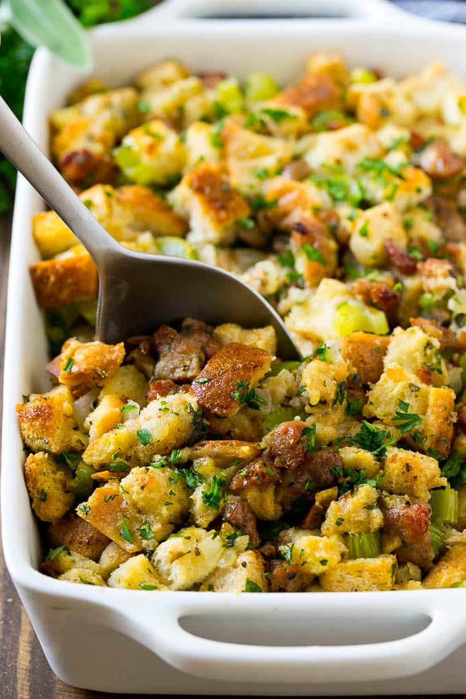 Sausage Stuffing Recipe | Thanksgiving Stuffing | Make Ahead Stuffing #stuffing #thanksgiving #sausage #sidedish #dinner #bajap A baking dish of sausage stuffing with a serving spoon in it.