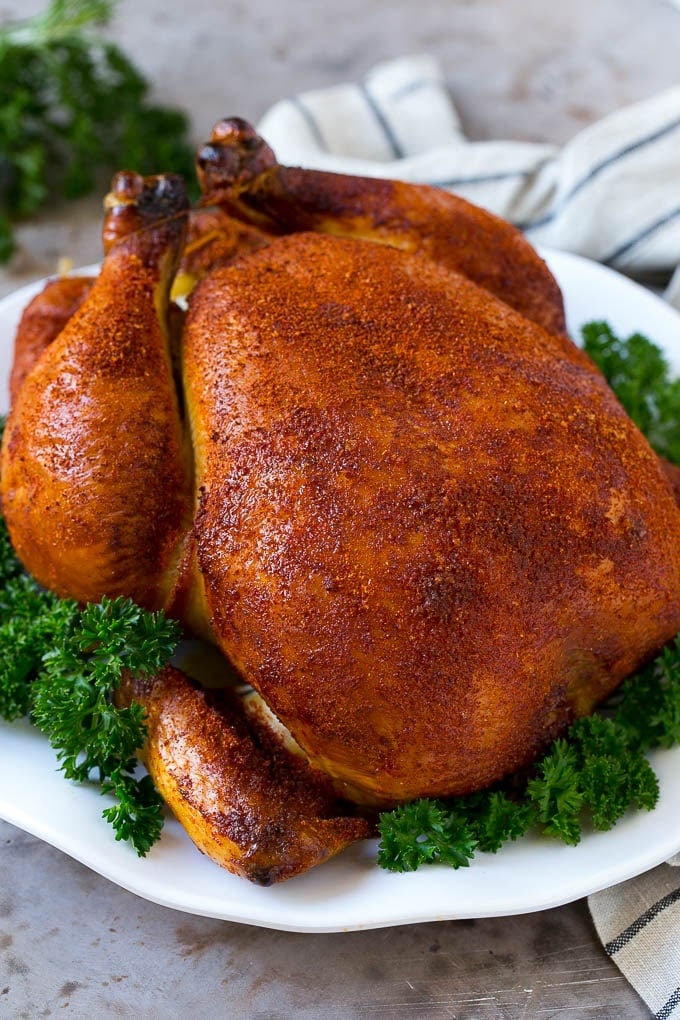 Smoked Chicken Recipe | Whole Smoked Chicken | BBQ Chicken #chicken #smoker #BBQ #dinner #bajap #glutenfree #lowcarb Smoked chicken on a serving platter garnished with parsley.