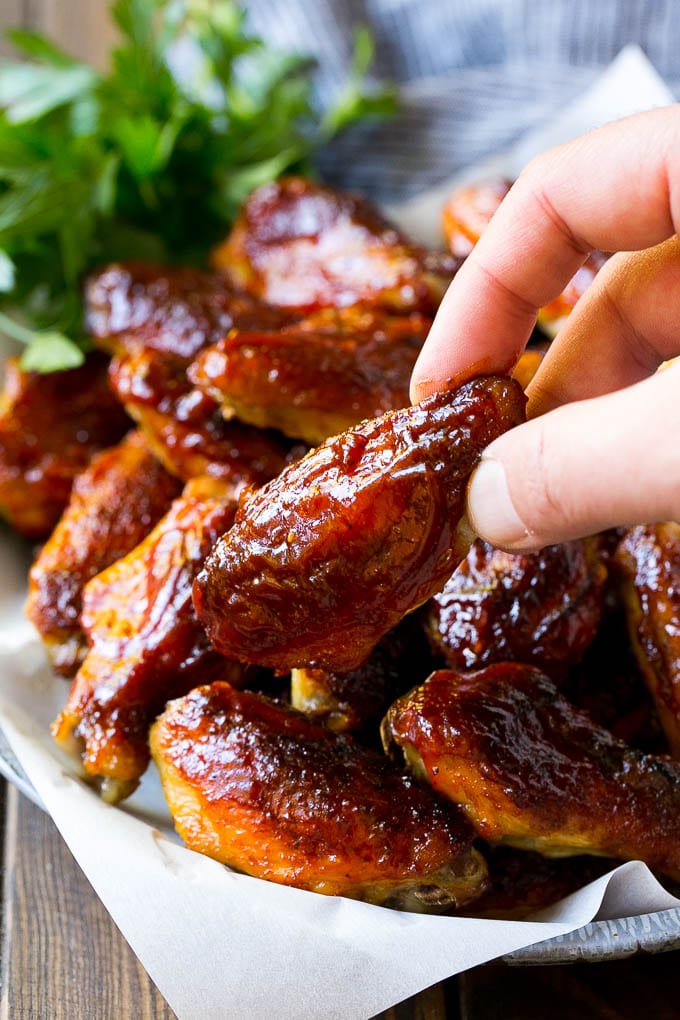 Smoked Chicken Wings | Barbecue Chicken Wings | BBQ Chicken Wings #chicken #wings #bbq #barbecue #appetizer #dinner #bajap A pile of smoked chicken wings with a hand reaching out for one.