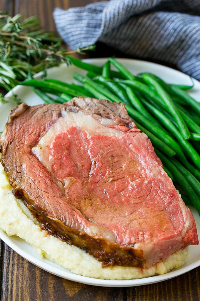 Smoked Prime Rib Recipe | Easy Prime Rib | Smoked Beef | Holiday Prime Rib #primerib #beef #smoker #dinner #bajap #christmas #thanksgiving #lowcarb #keto A slice of prime rib over mashed potatoes with green beans on the side.
