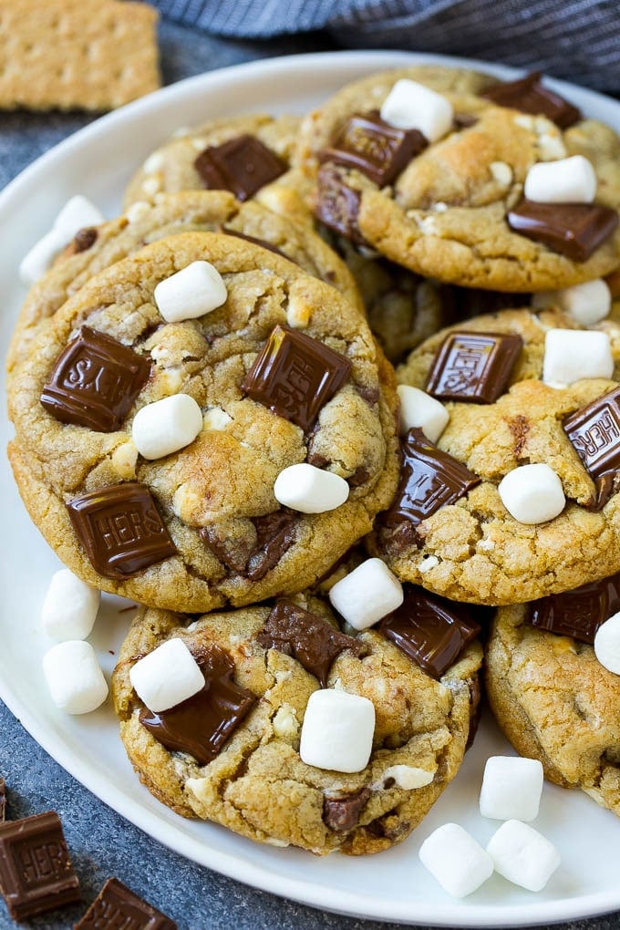 S'mores Cookies Recipe | Marshmallow Cookies #smores #marshmallow #chocolate #cookies #dessert #bajap A plate of S'mores cookies topped with milk chocolate bars and marshmallows.