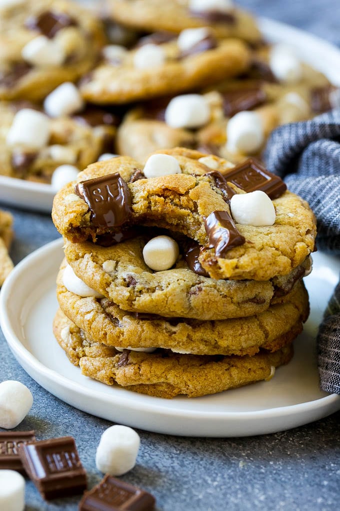 S'mores Cookies Recipe | Marshmallow Cookies #smores #marshmallow #chocolate #cookies #dessert #bajap A stack of S'mores cookies with a bite taken out of one.