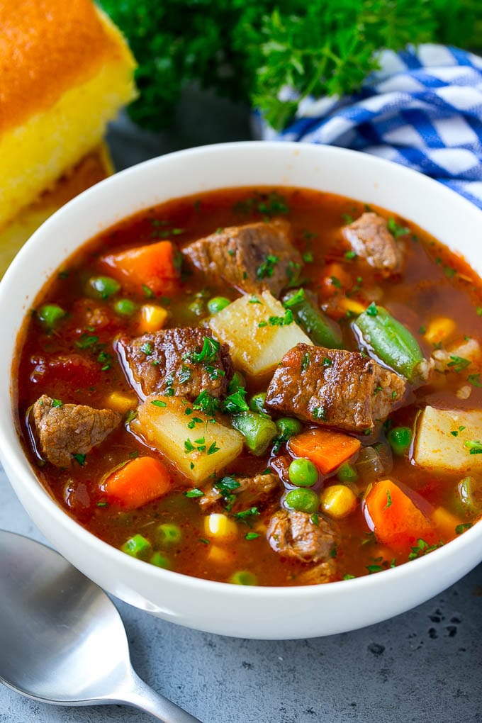 Vegetable Beef Soup Recipe | Beef Vegetable Soup | Beef Soup #beef #veggies #soup #dinner #glutenfree #bajap A bowl of vegetable beef soup with carrots, celery, onions, potatoes, tomatoes, corn and peas.