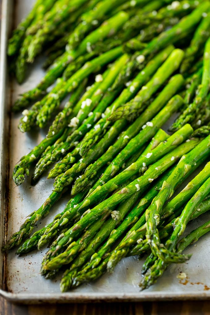 Roasted Asparagus Recipe | Baked Asparagus | Asparagus Side Dish #asparagus #garlic #sidedish #keto #lowcarb #dinner #bajap Roasted stalks with garlic and olive oil on a baking sheet.